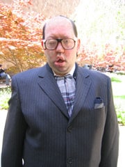 Picture of Matthew Joffe. He is Caucasian male, fair skin with short, dark hair and he is wearing glasses. He is wearing a gray suit jacket with a patterned shirt underneath