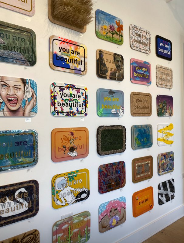 YAB-boards 'you are beautiful' boards on a wall. each is painted in a unique way.