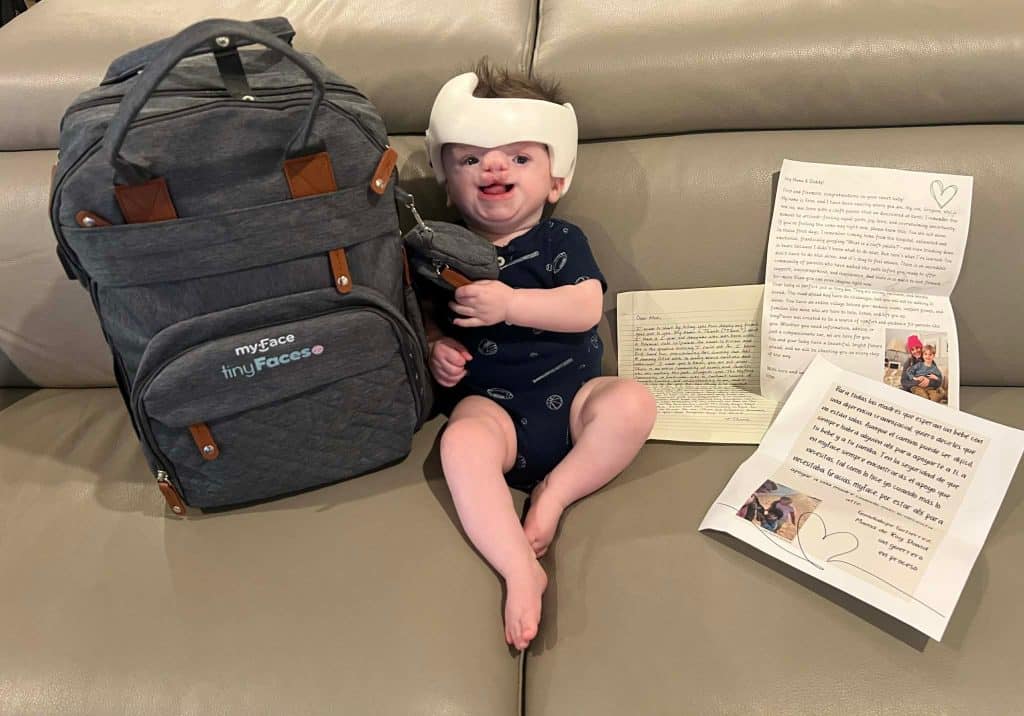 baby Leo posing on the couch with tinyFaces backpack